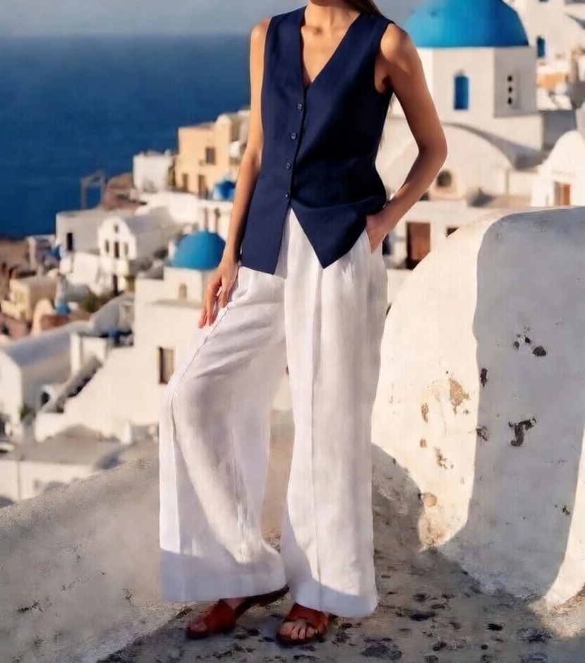 Person walking through whitewashed Santorini streets in navy tones
